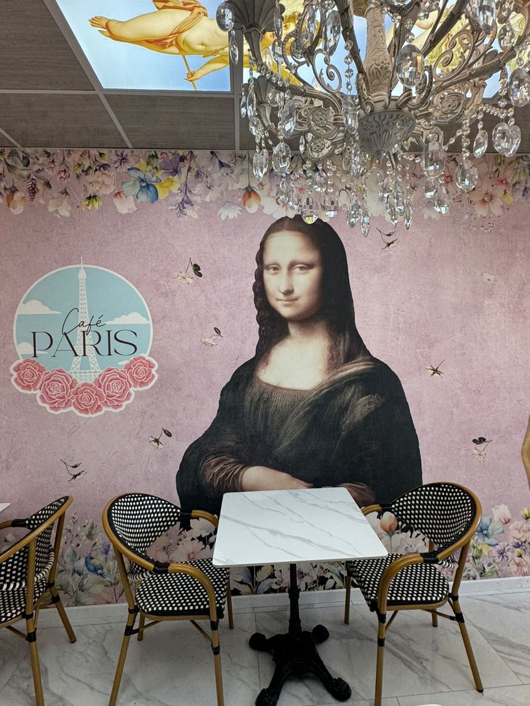 Mesas del Café París junto a los murales